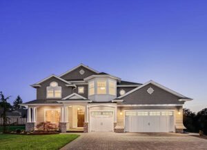A large home featuring a spacious driveway and an attached garage.