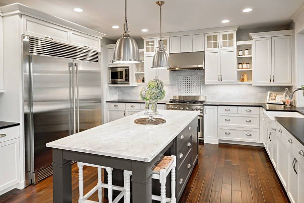 A modern kitchen featuring white cabinets and sleek black countertops.