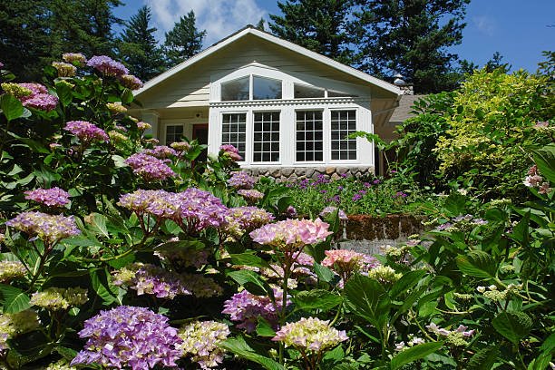 A charming house with a colorful flower garden in front, highlighting custom home remodeling features.