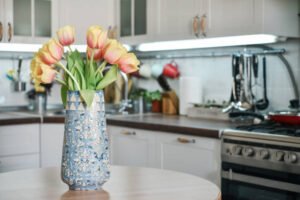 Bright yellow tulips in a vase on a kitchen table, showcasing the vibrant decor of a kitchen renovation.