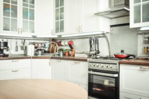 Kitchen Renovation displaying white cabinets and a wooden table, emphasizing a contemporary design.