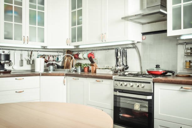 Kitchen Renovation displaying white cabinets and a wooden table, emphasizing a contemporary design.